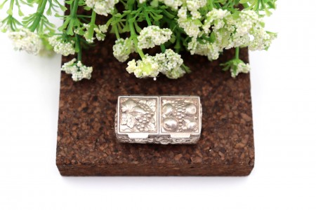 Caixa de comprimidos em prata com compartimento duplo e elementos em alto relevo